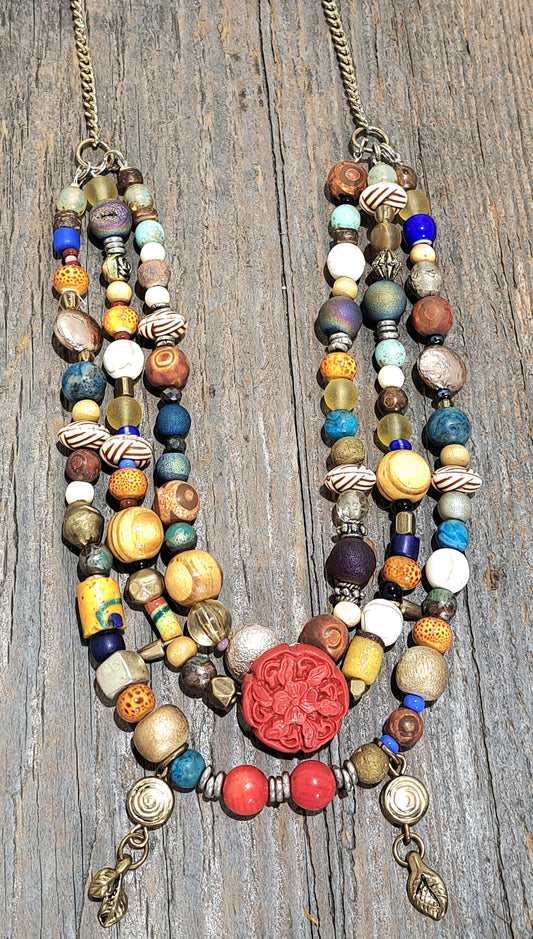 Triple strand multibead necklace on brass chain.