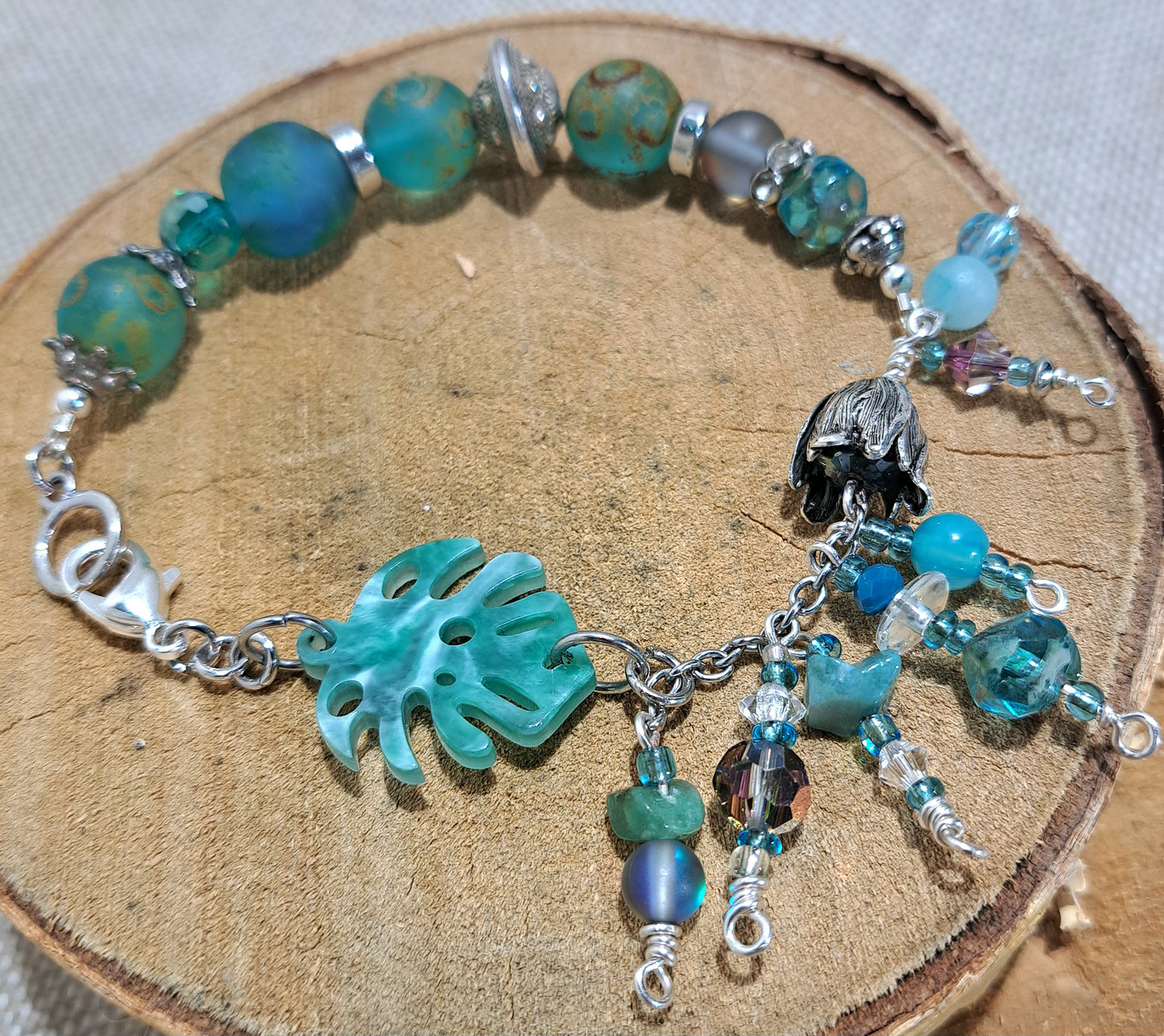 Ladies bracelet of blue/green recycled African glass and leaf focal.