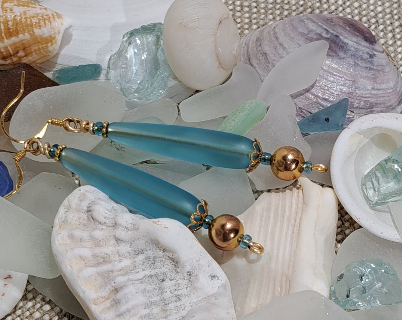 Ladies pale blue drop sea glass earring with gold bead and filigree.