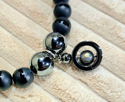 Unisex stretch bracelet of Black Onyx with polished stripe detail and Hematite Charm.