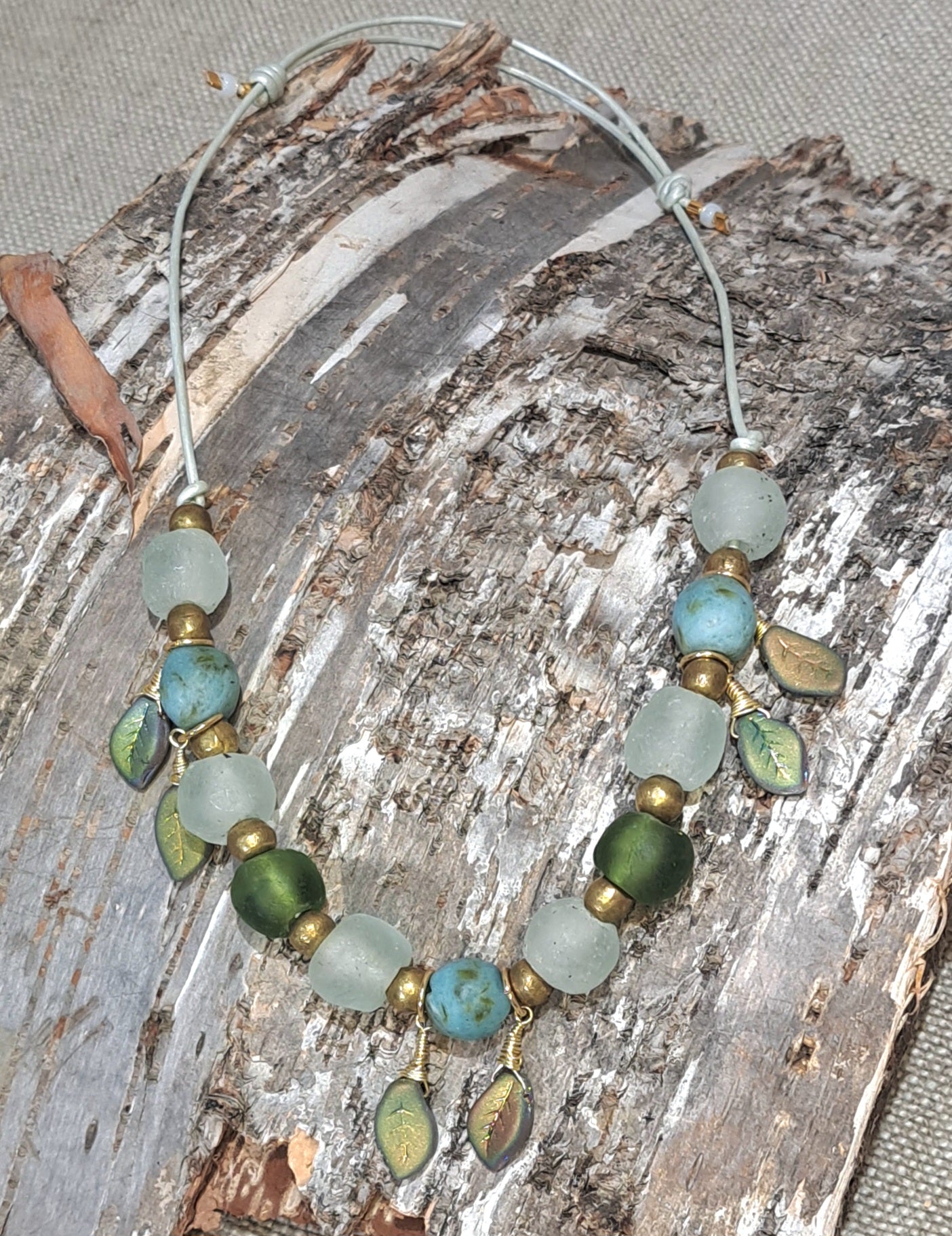 Ladies African recycled glass large bead necklace strung with pale sea green leather adjustable strap.