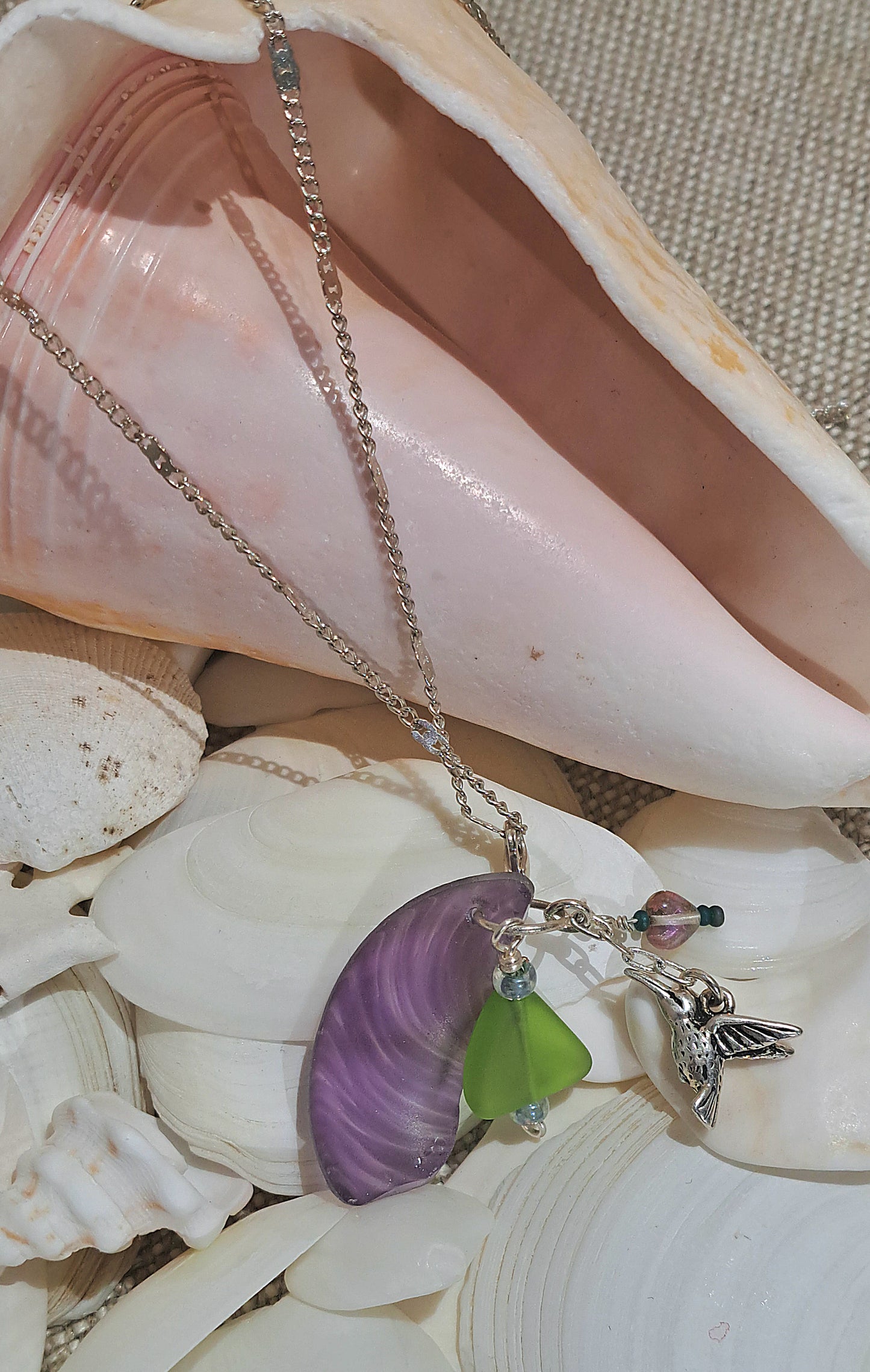 Hummingbird Charm and Purple strie Sea Glass necklace.