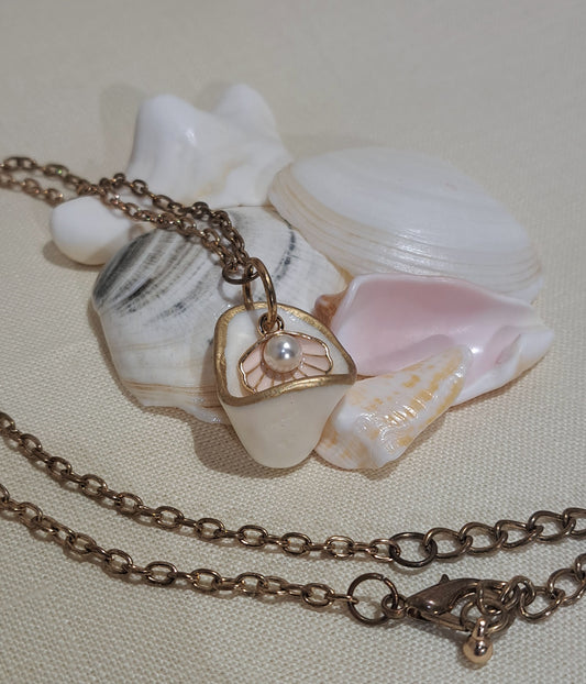 Cup shaped sea shell pendant with pink clam shell charm and hanging pearl.