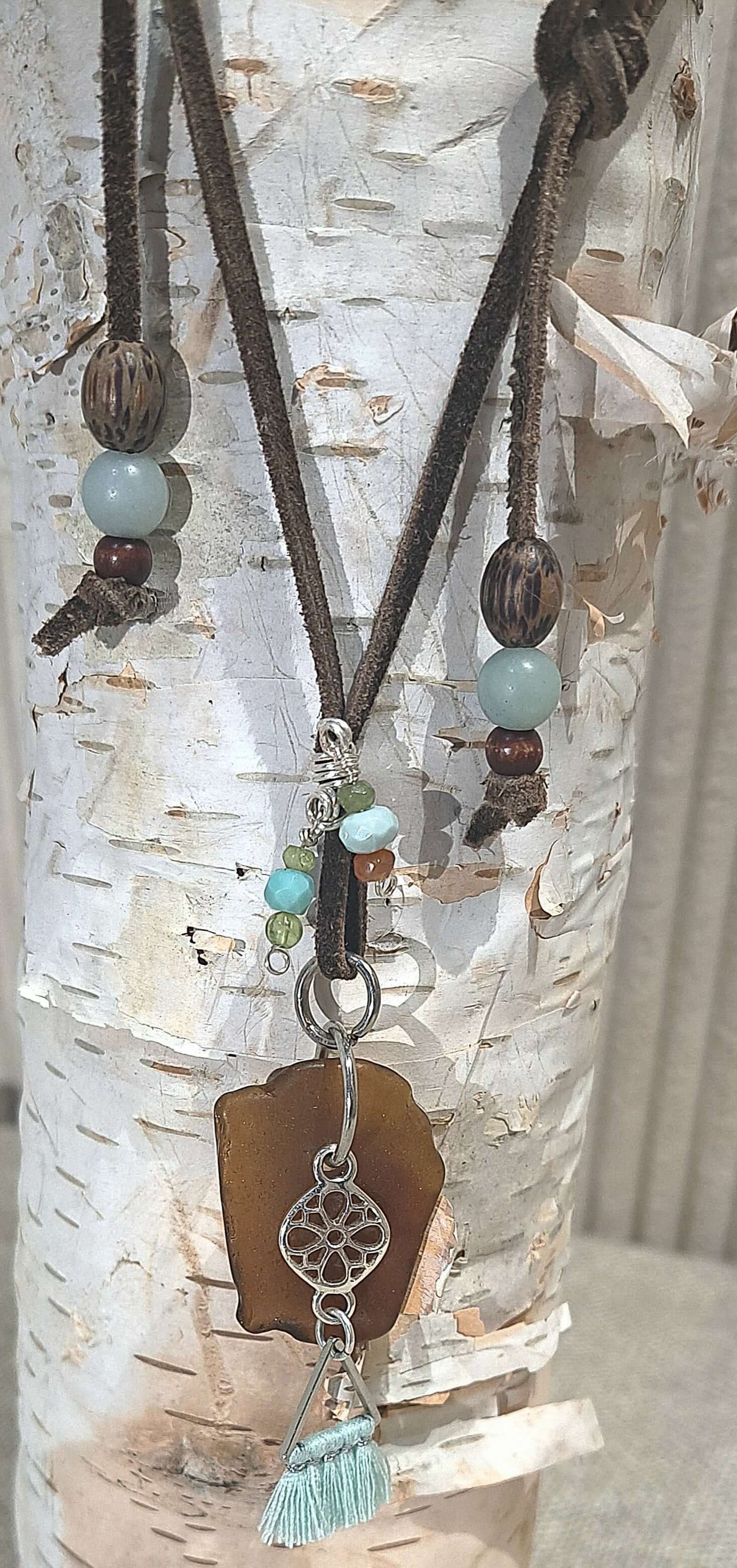 Brown suede adjustable necklace with a brown large sea glass focal and pale sea foam green accent beads and a steel filigree square charm.