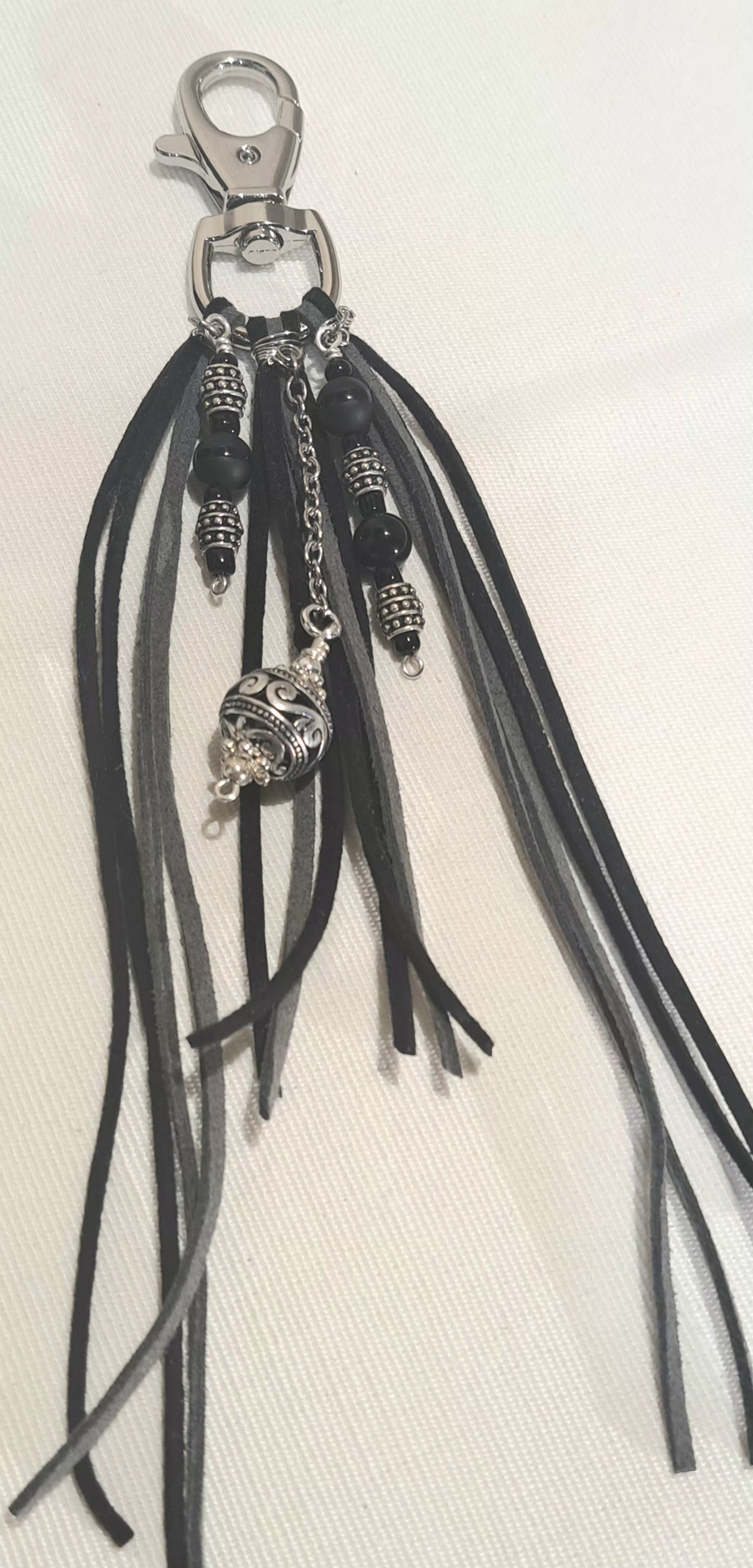 Black and grey suede tassel bag charm with steel focals.