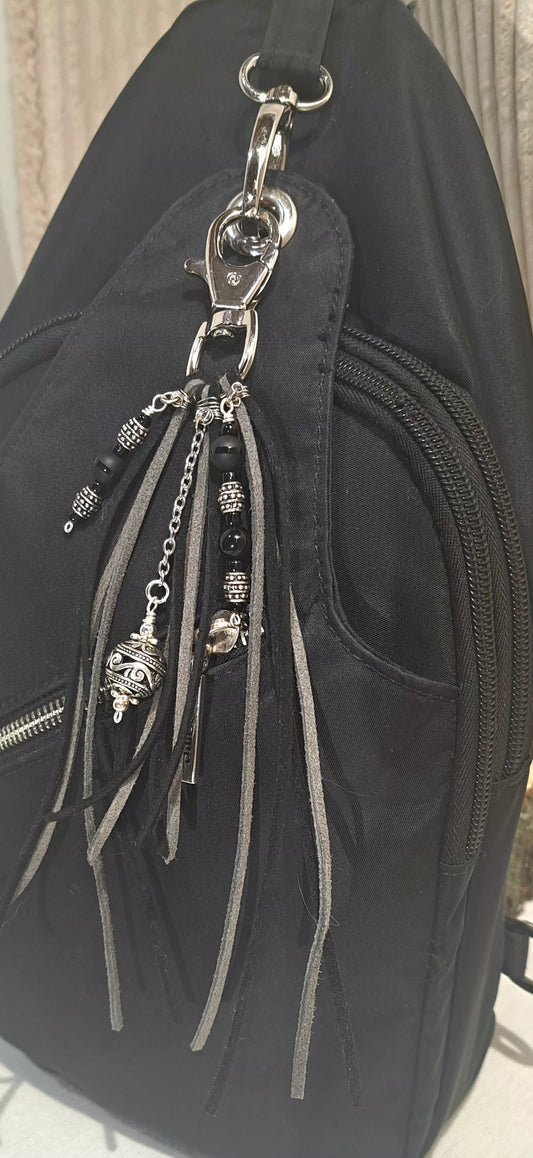 Black and grey suede tassel bag charm with steel focals.
