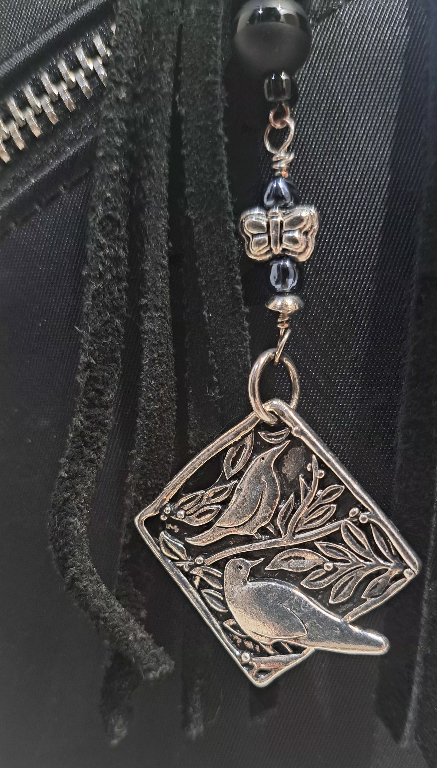 Black suede tassel bag charm with black onyx, black glass, and steel accent beads.