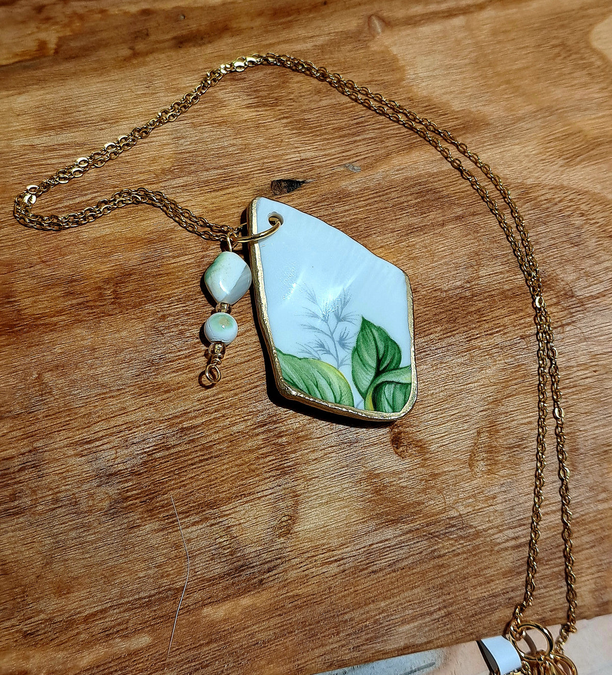 Broken china trillium floral pendant hung on gold plated chain