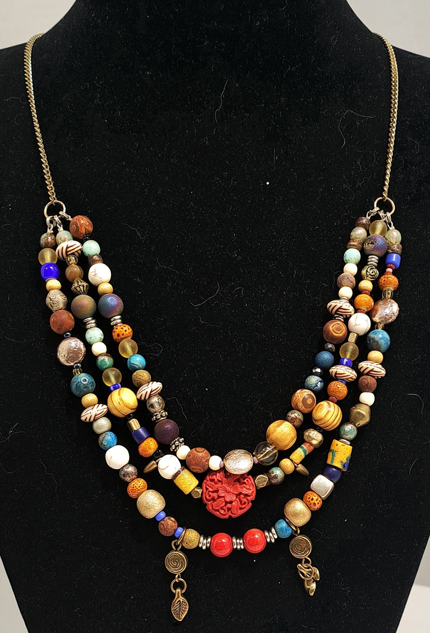 Triple strand multibead necklace on brass chain.