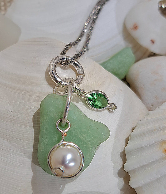 Ladies sterling silver necklace with pale green sea glass and hanging pearl and charm.