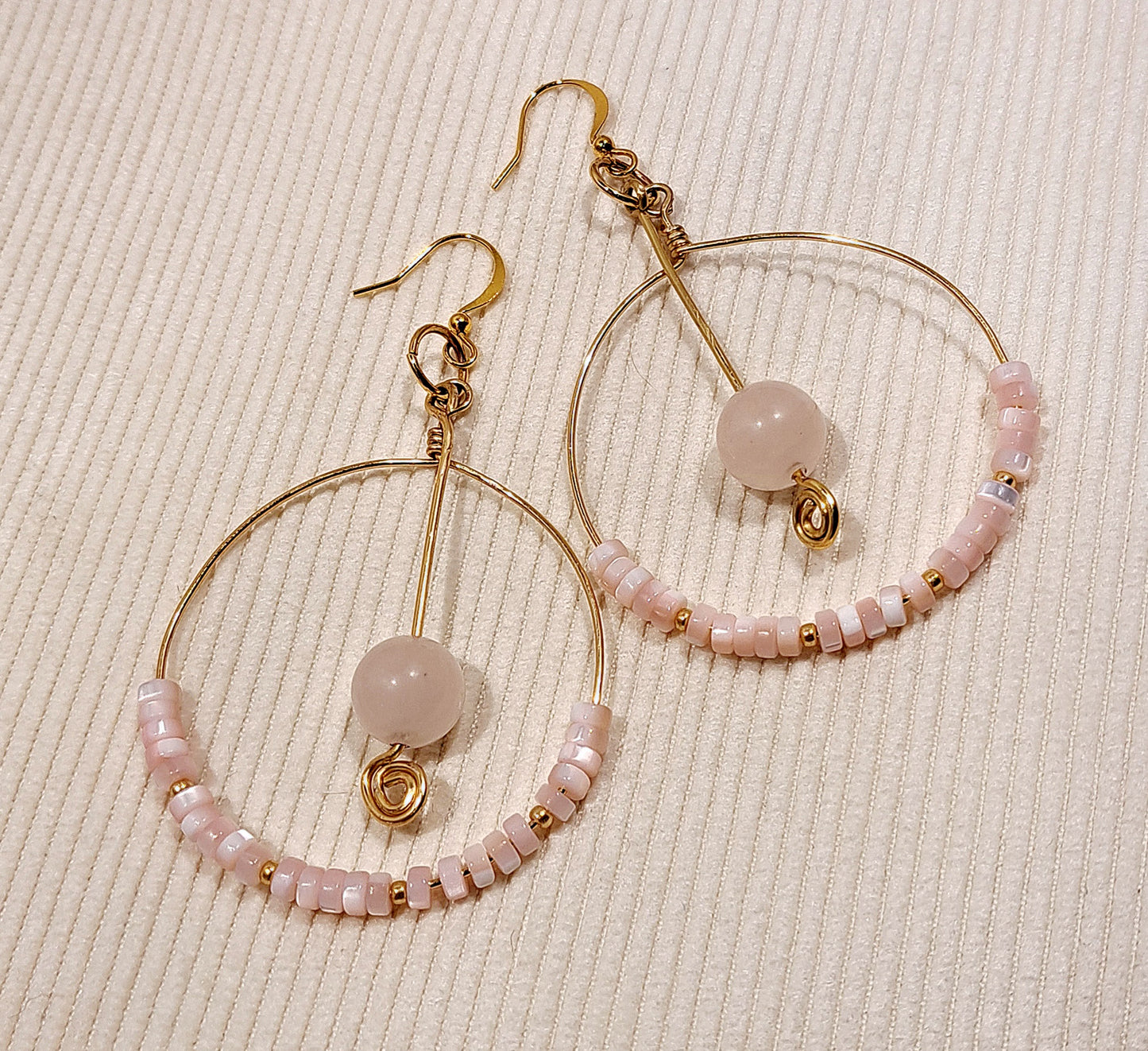 Ladies gold hoop earrings with pink quartz and pink mother of pearl.