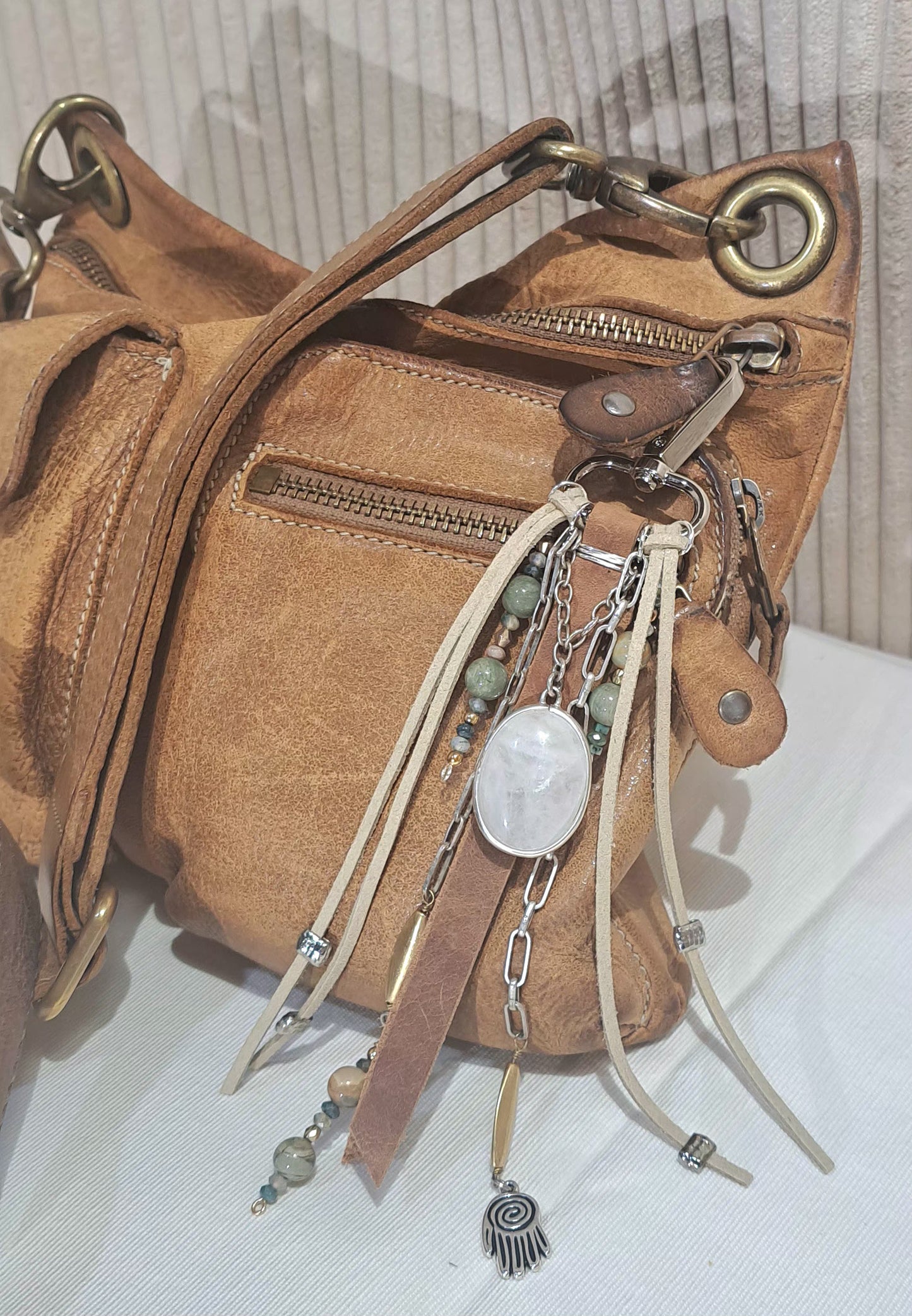 Distressed brown leather bag charm with large ivory quartz focal .