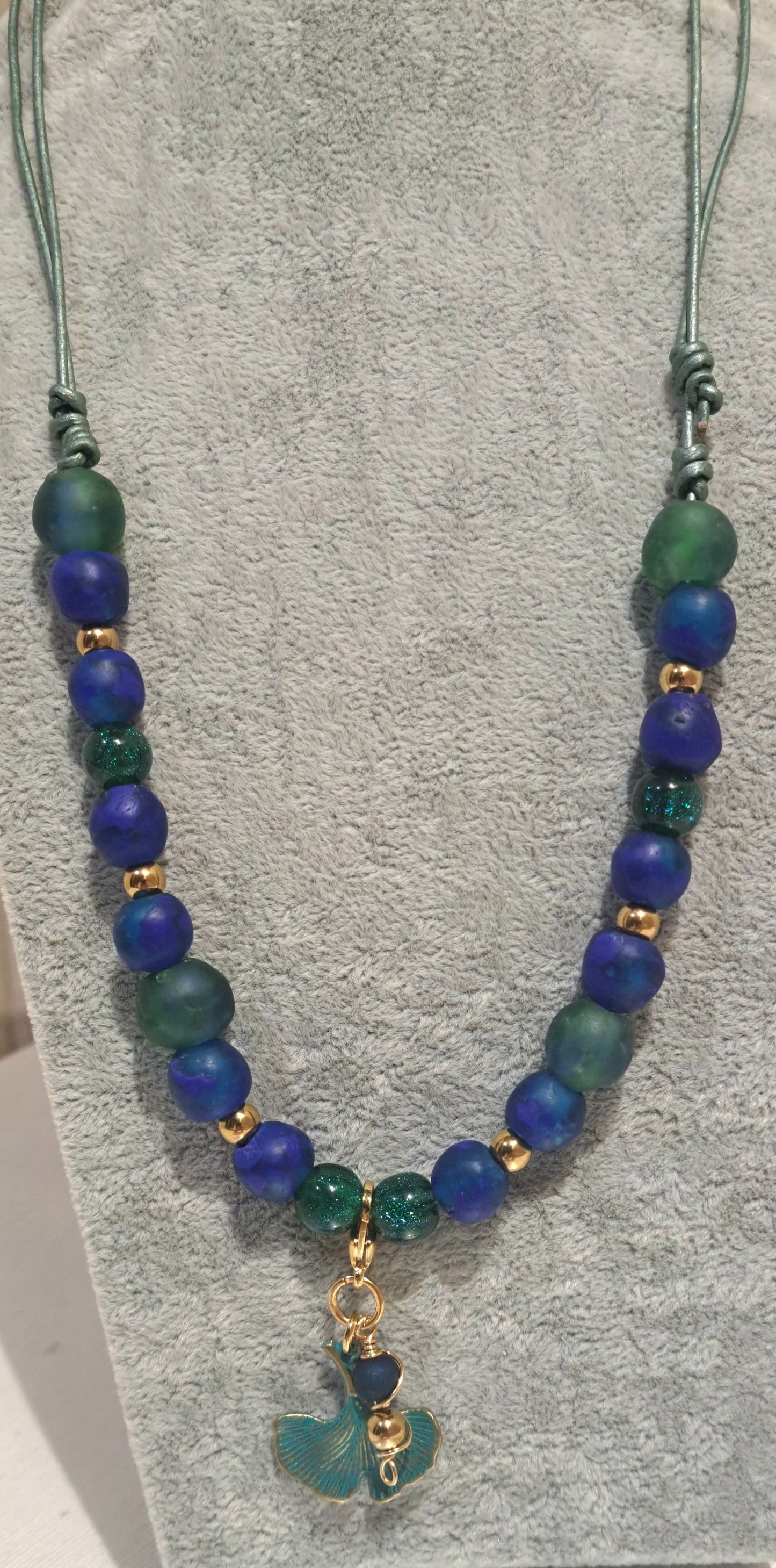 hanging necklace of blue green recycled African glass and Ginko charm pendant