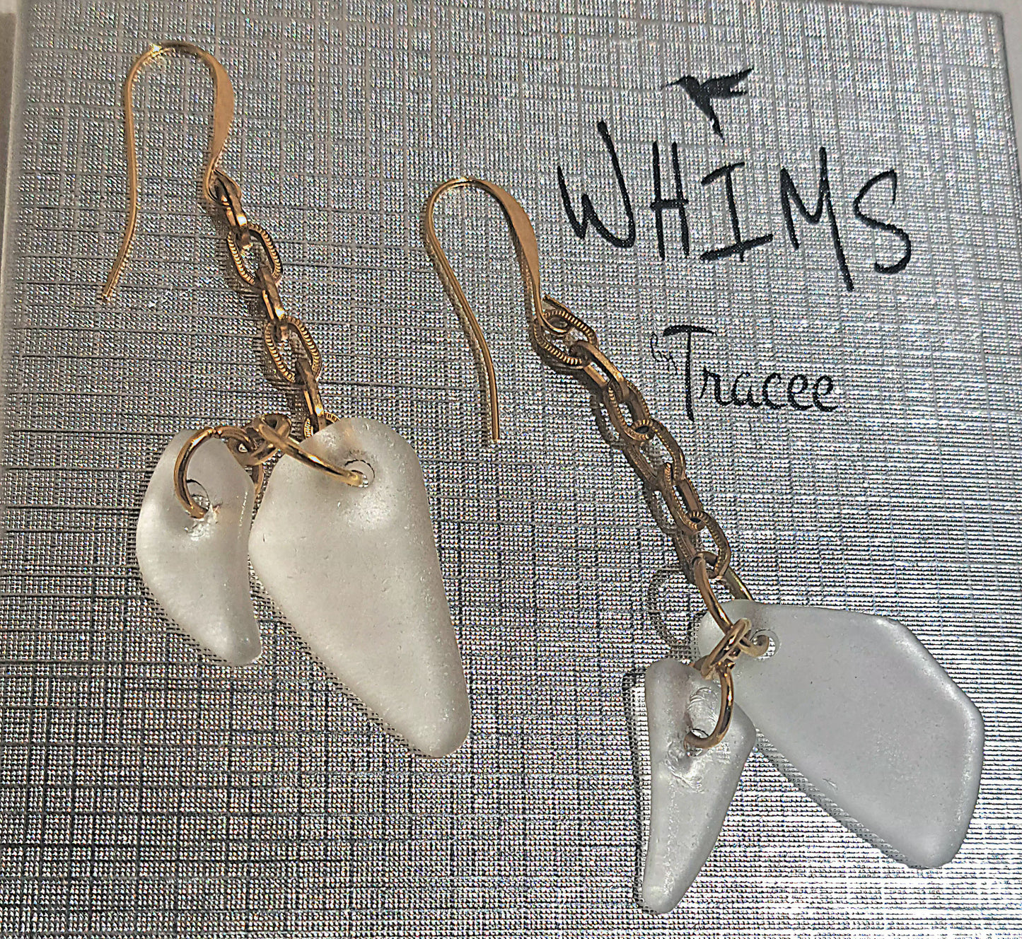 close up of Clear sea glass earrings set on Whims gift box