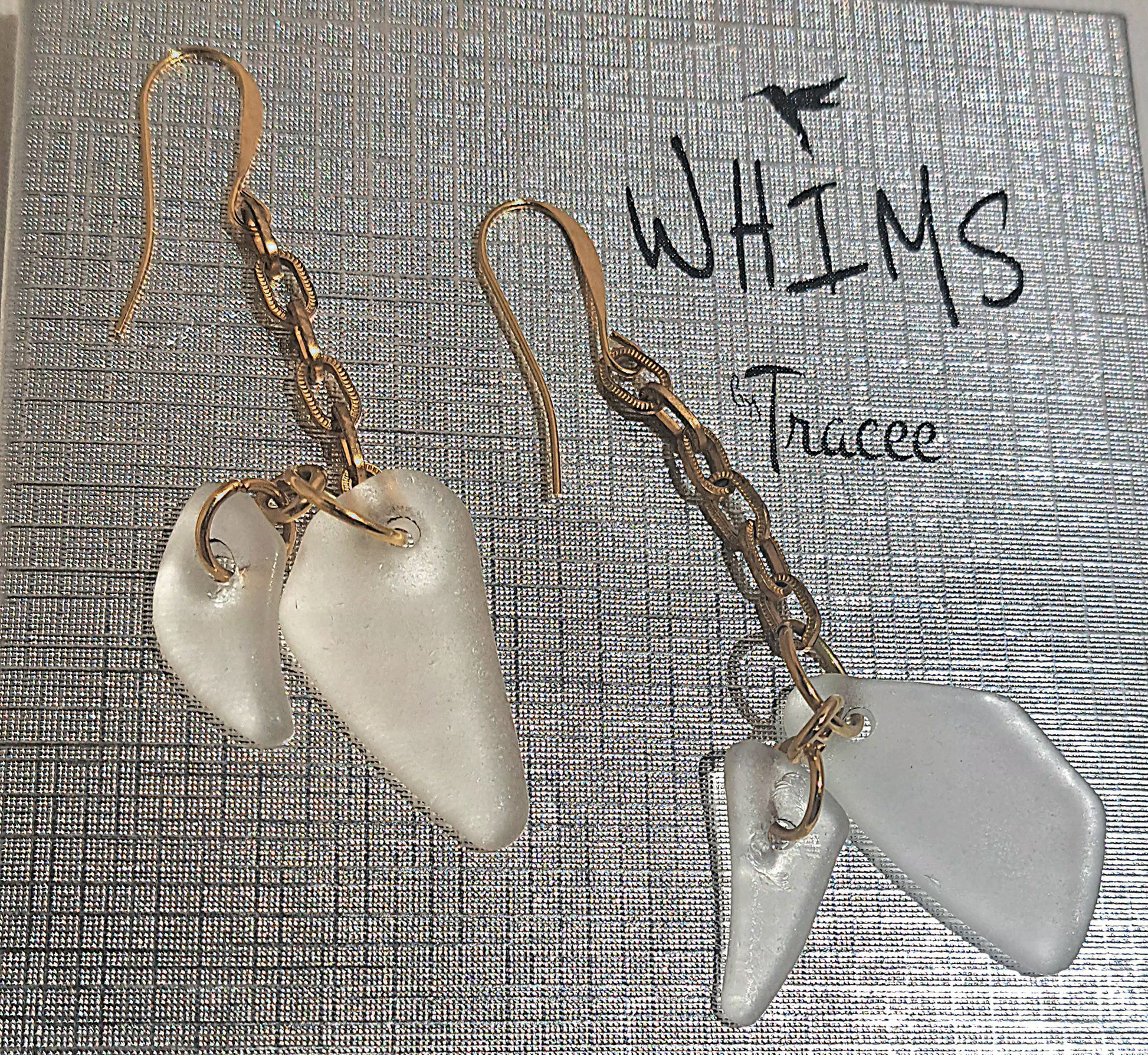 close up of Clear sea glass earrings set on Whims gift box