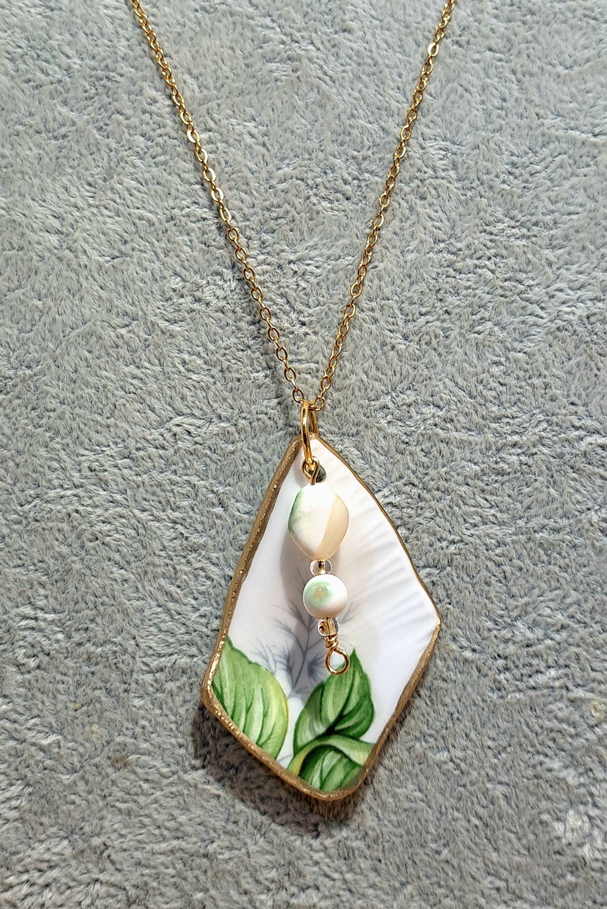 Broken china  trillium floral pendant hung on gold plated chain
